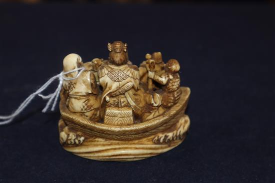 A Japanese ivory okimono netsuke of a dog with a mallet